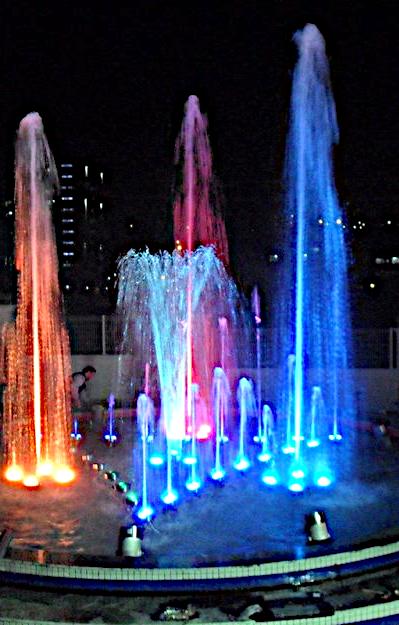 Tall fountain jets lit red and blue