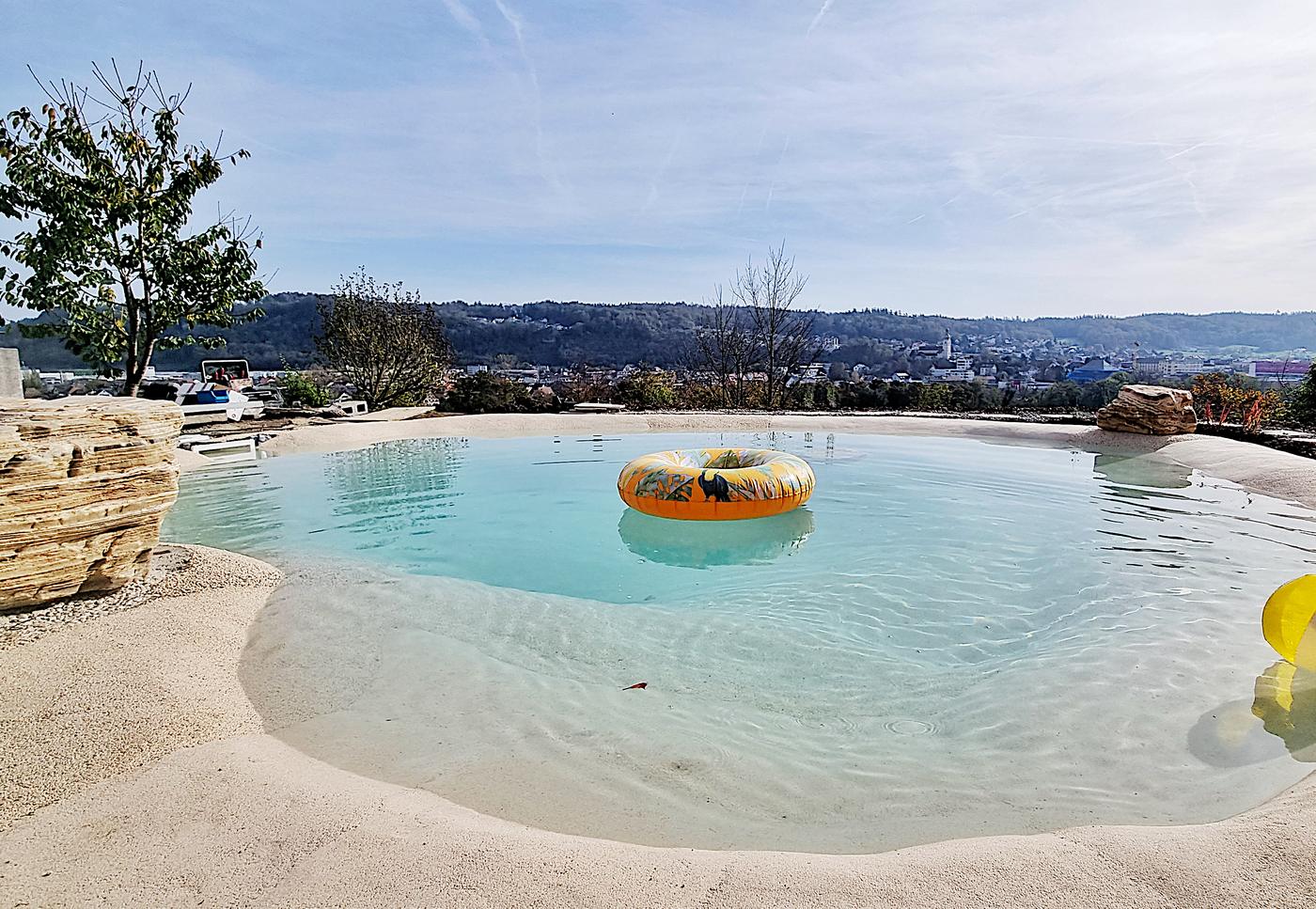 Lagoon pool with a sandy shoreline and rocks