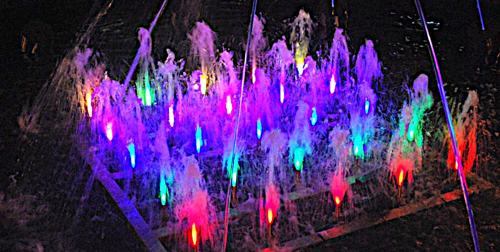 Rows of colour-lit water jets at night