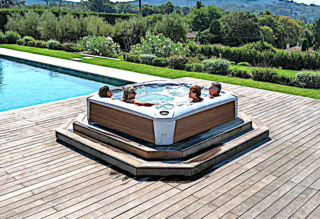 Hot tub on a wooden deck beside a pool