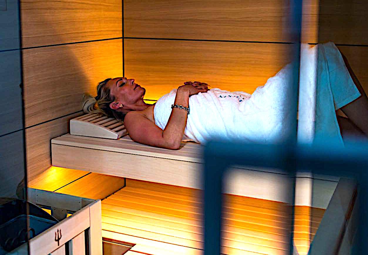 Woman relaxing in a warmly lit sauna