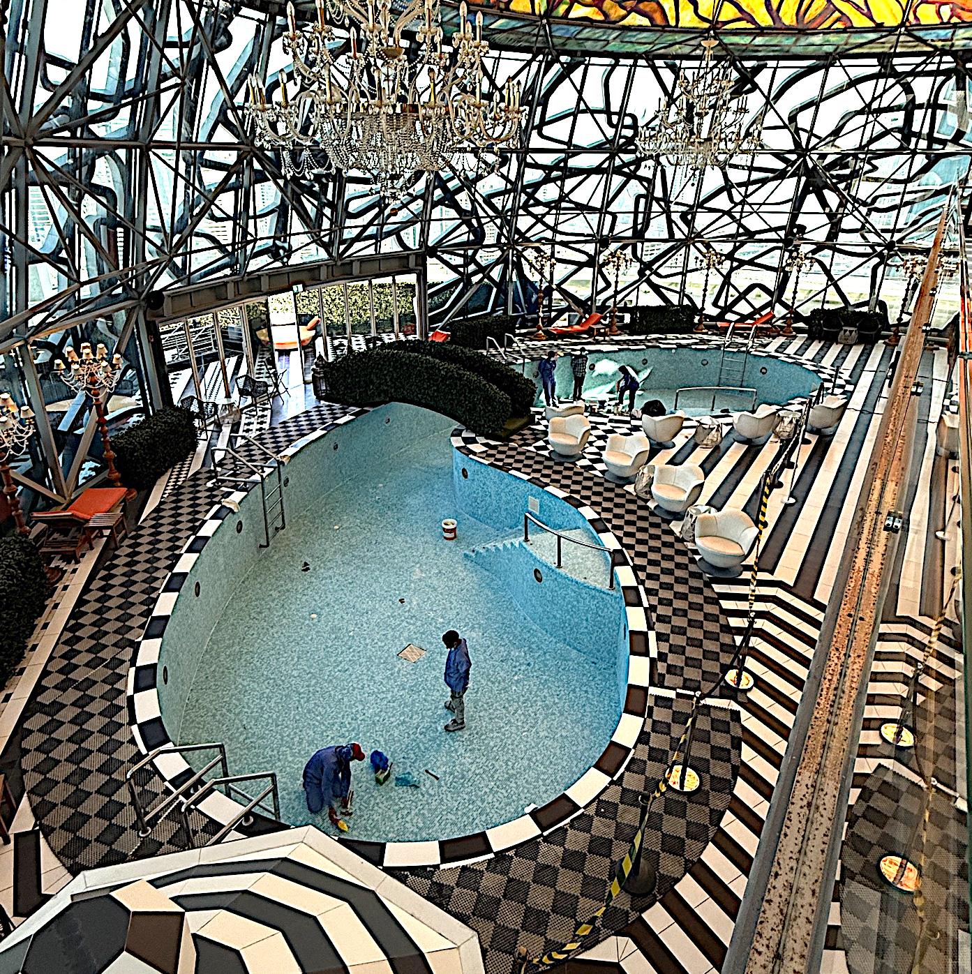 Pool being refurbished inside a hall with bold black and white patterned walls