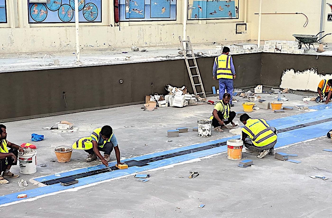 Team laying tiles on a new pool deck