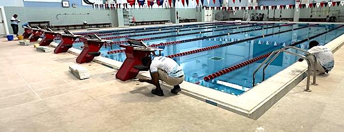 Technician working at the edge of an indoor competition pool